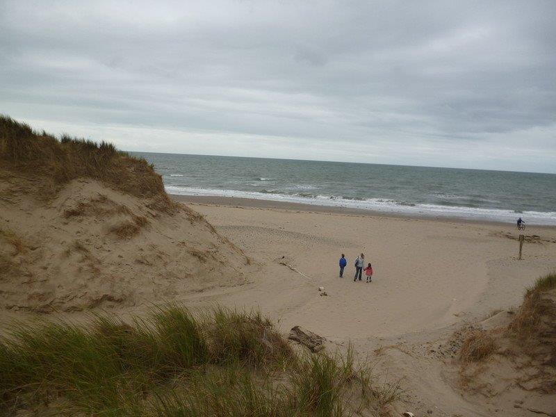 People on a beach near some sand dunes
