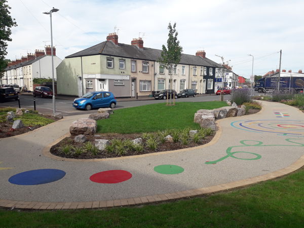 A photo of Albany Street in Newport showing a new foot path with a colourful play trail with shapes and lines on the ground A photo of Albany Street in Newport showing a new foot path with a colourful play trail with shapes and lines on the ground