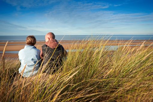 Couple Sitting On Grass At Gronant Dunes