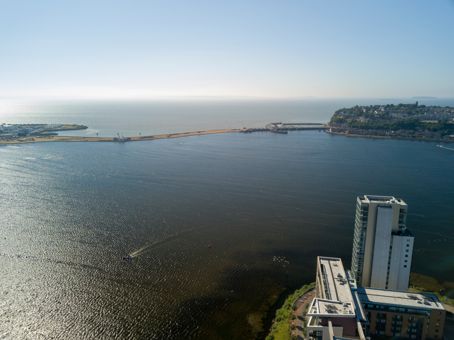 Golygfa o fae Caerdydd yn dangos Adeiladau uchel a'r môr