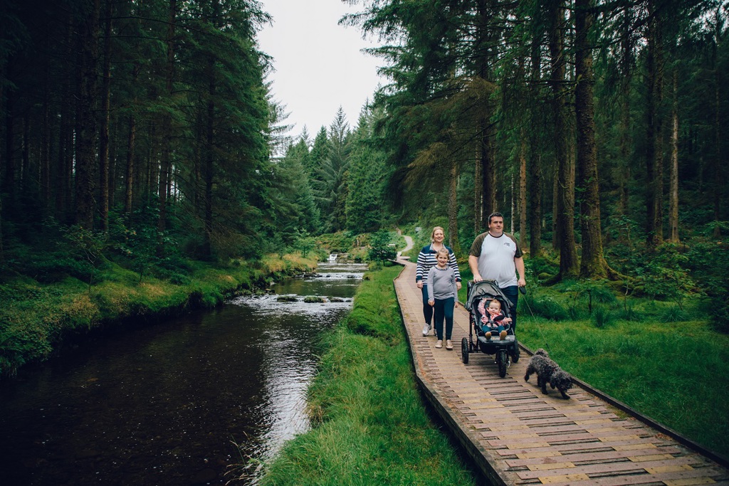 Family following the accessible Cascades Walk boardwalk beside the River Severn in Hafren Forest