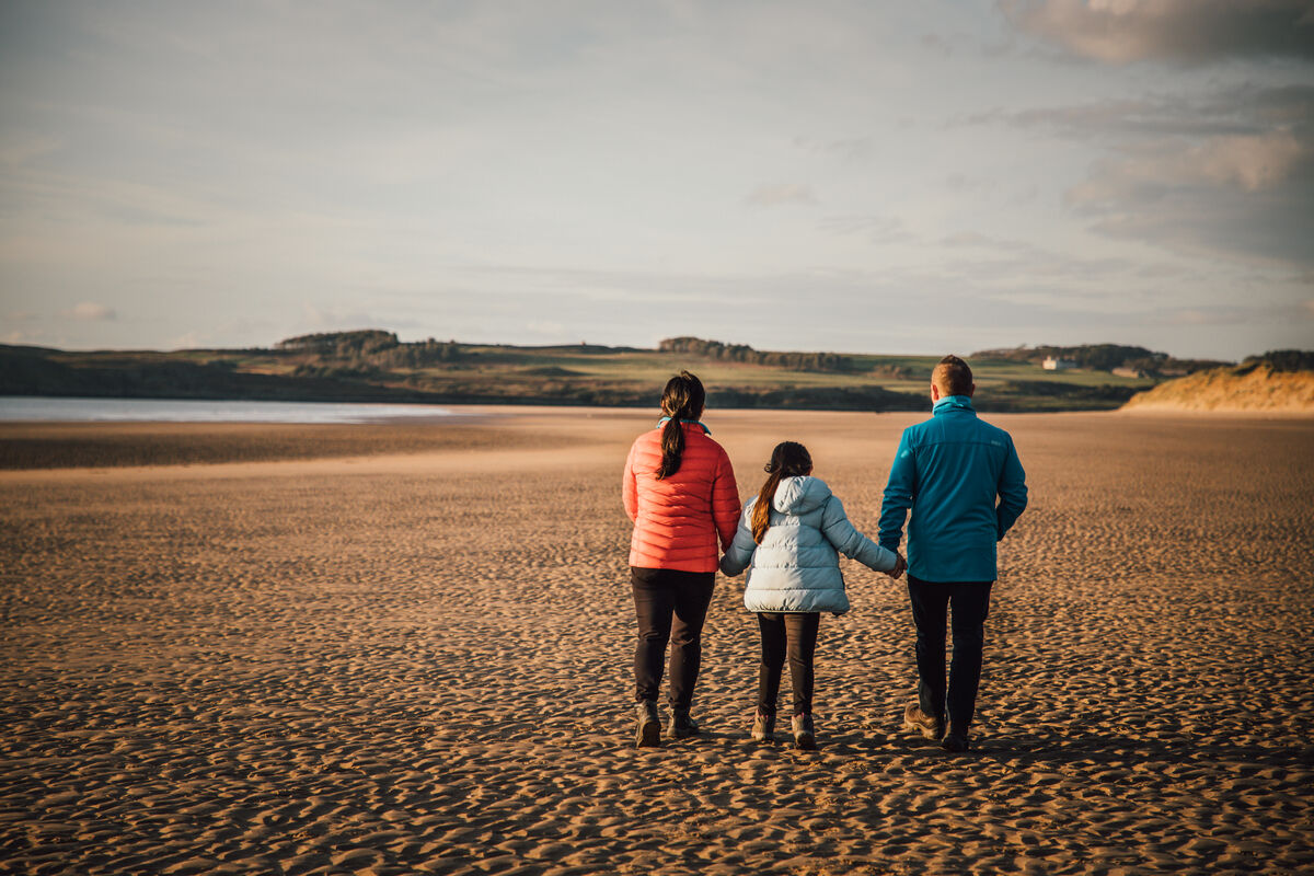 A family walks on the beach