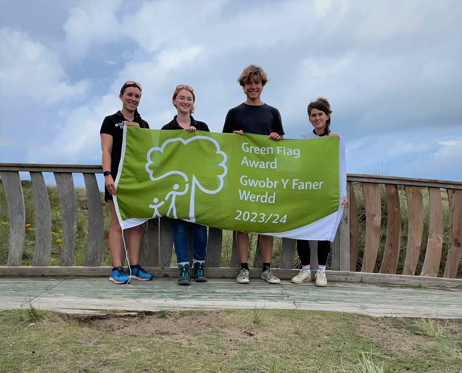  Staff canolfan ymwelwyr yn dal Gwobr y Faner Werdd