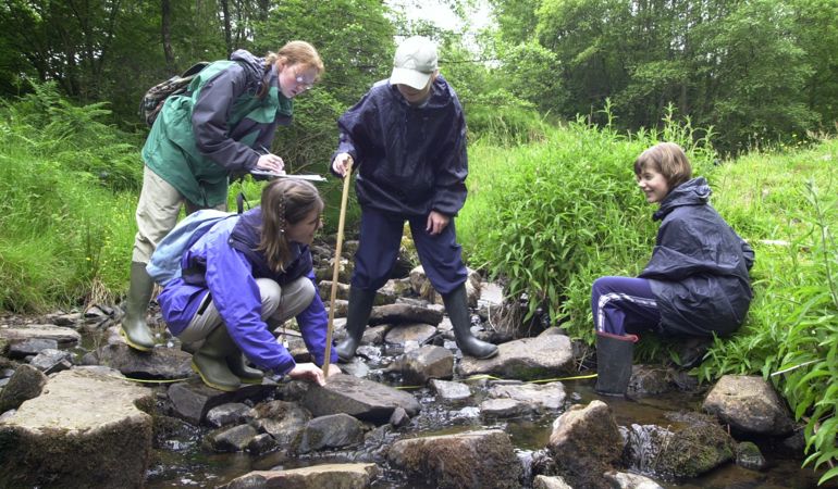 Children measuring the river Children measuring the river
