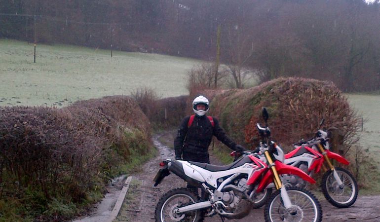 Man standing next to scrambler bikes Man standing next to scrambler bikes