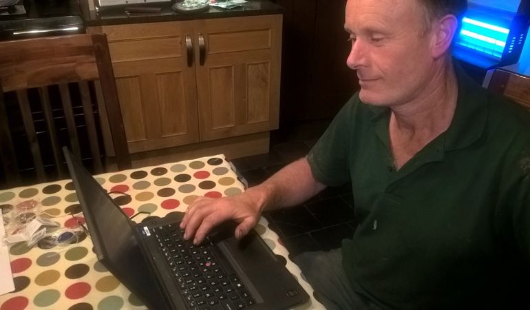 Man sitting at the kitchen table with laptop Man sitting at the kitchen table with laptop