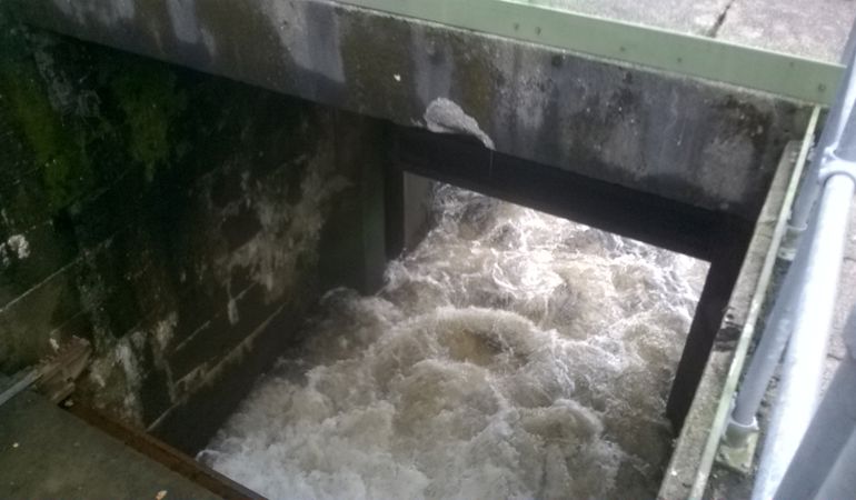 Sluce gate with water pouring into the river Sluce gate with water pouring into the river