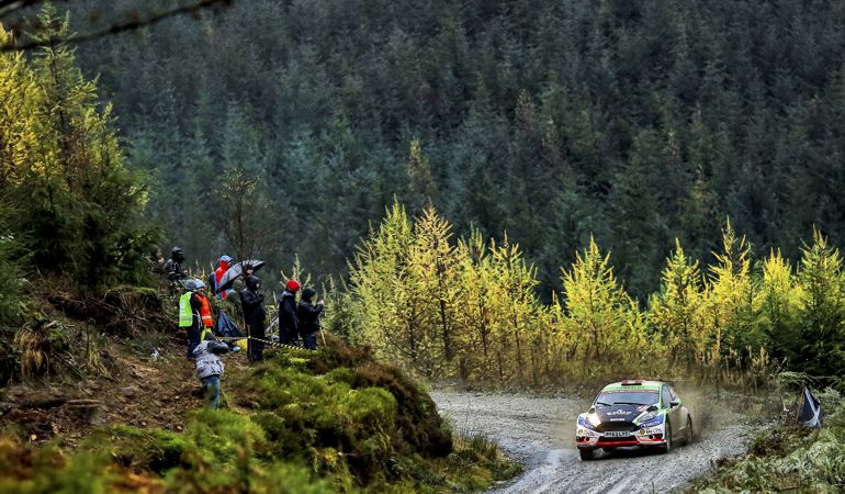 Rally car on mountain road with trees in the background Rally car on mountain road with trees in the background