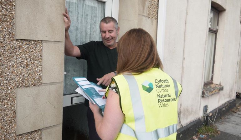 NRW staff member explaining a flood plan to a member of the public NRW staff member explaining a flood plan to a member of the public