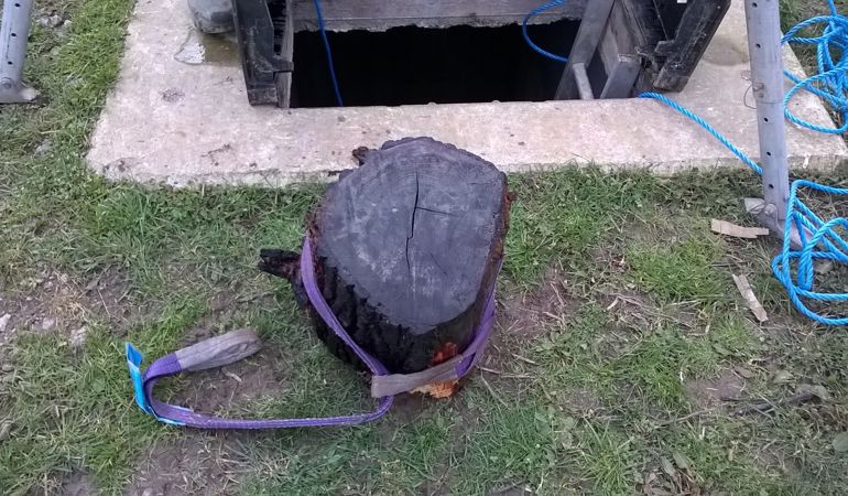 A large log on the ground next to the opening to the tidal flap with a lifting strap attached A large log on the ground next to the opening to the tidal flap with a lifting strap attached