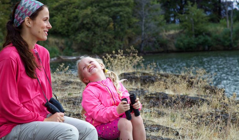 A woman and a little girl sat on a river bank A woman and a little girl sat on a river bank