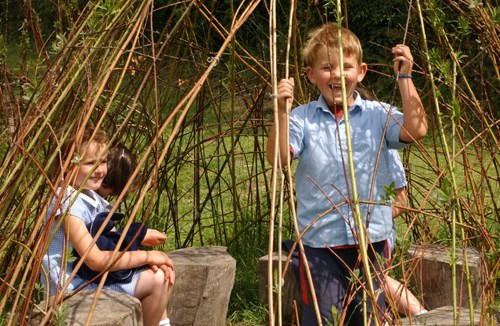 Children playing in school grounds willow dome Ysgol Cynddelw. Glyn Ceiriog. Wrexham