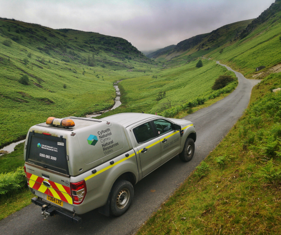 Delwedd o gerbyd Cyfoeth Naturiol Cymru ar ffordd yng nghefn gwlad