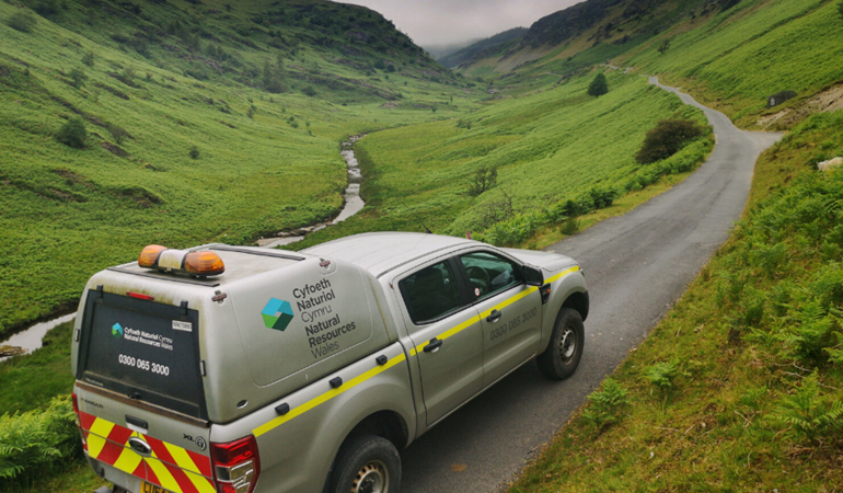 Image of an Natural Resources Wales vehicle on a road in the countryside 