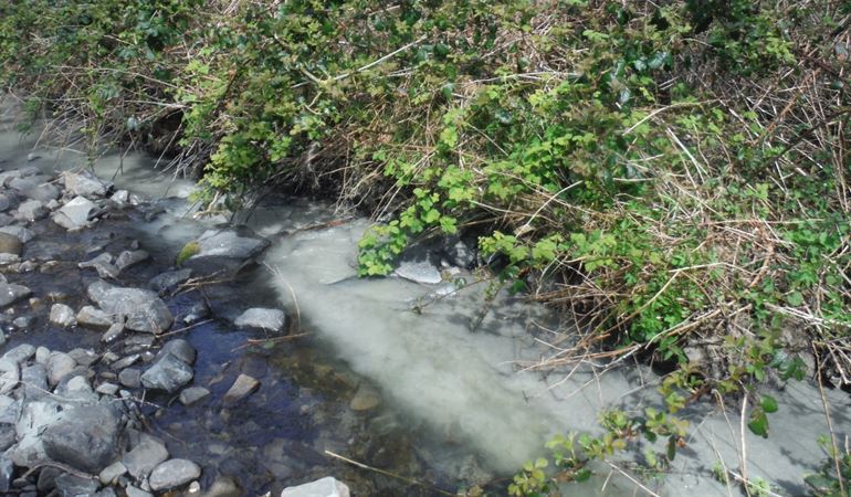 Thick sediment entering the Afon Drywi and flowing alongside clear water from upstream