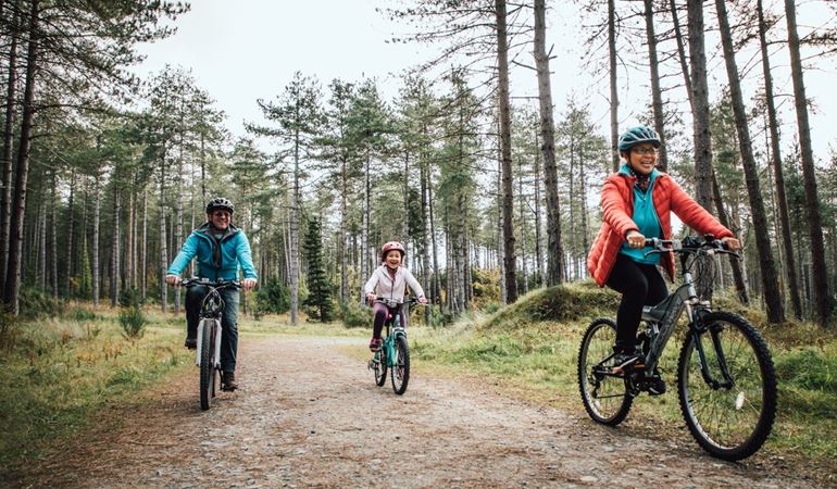Newborough - cycling family through woods