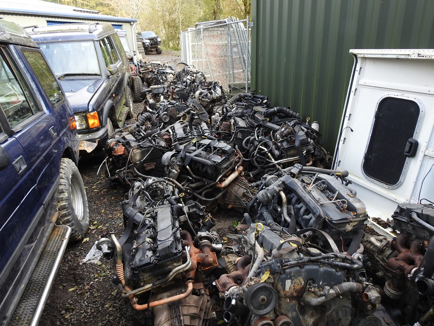 Two 4x4s and many engines on the floor in a yard