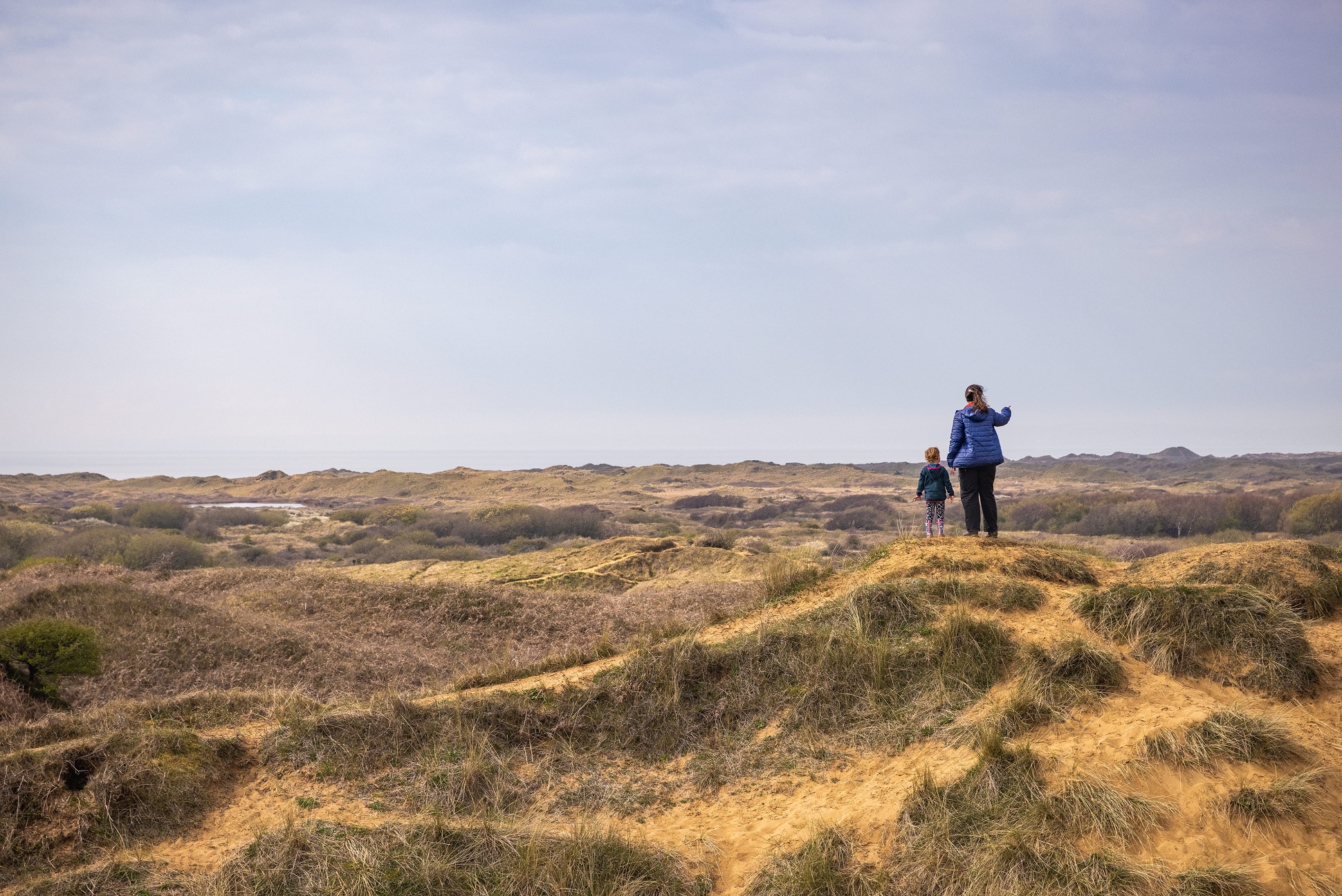 Mother and child standing on the sand dunes at Kenfig National Nature Reserve