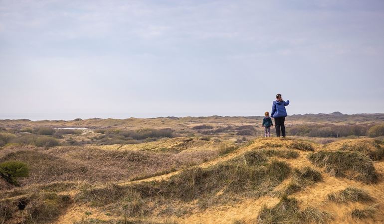 Mother and child standing on the sand dunes at Kenfig National Nature Reserve