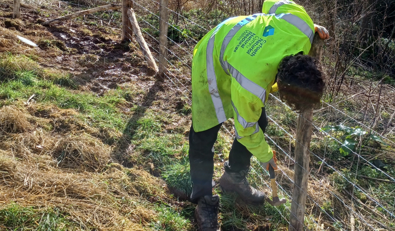 An officer from Natural Resources Wales installing fencing at Glen Farm in Monmouthshire 